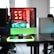 A modern gaming setup is displayed on a desk with multiple computer monitors and an open gaming PC tower. The tower is illuminated with red and green LED lights, showcasing a 'GeForce RTX' graphics card. A gaming mouse rests on a mousepad with glowing edges, and there is a keyboard with vibrant backlighting. The room appears well-lit with visible windows in the background.